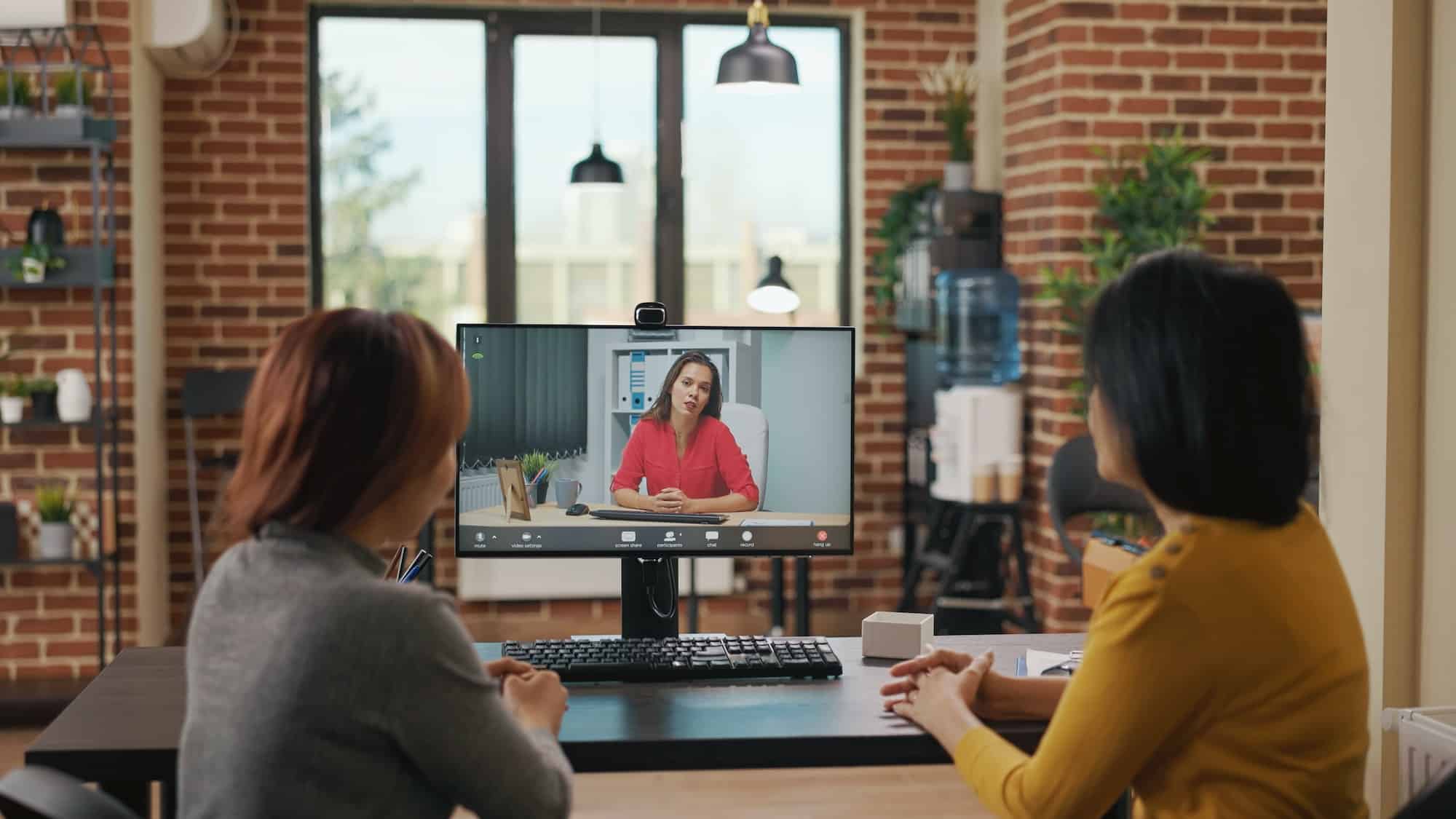 Colleagues using video call conference to recruit woman