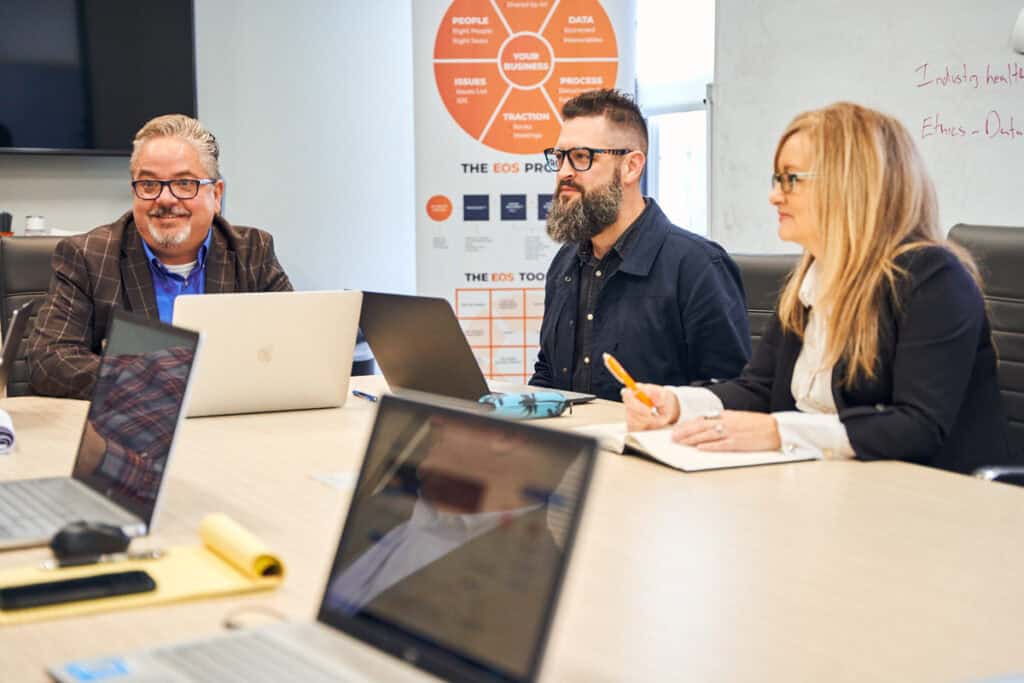 Business professionals discussing technology solutions at a meeting.